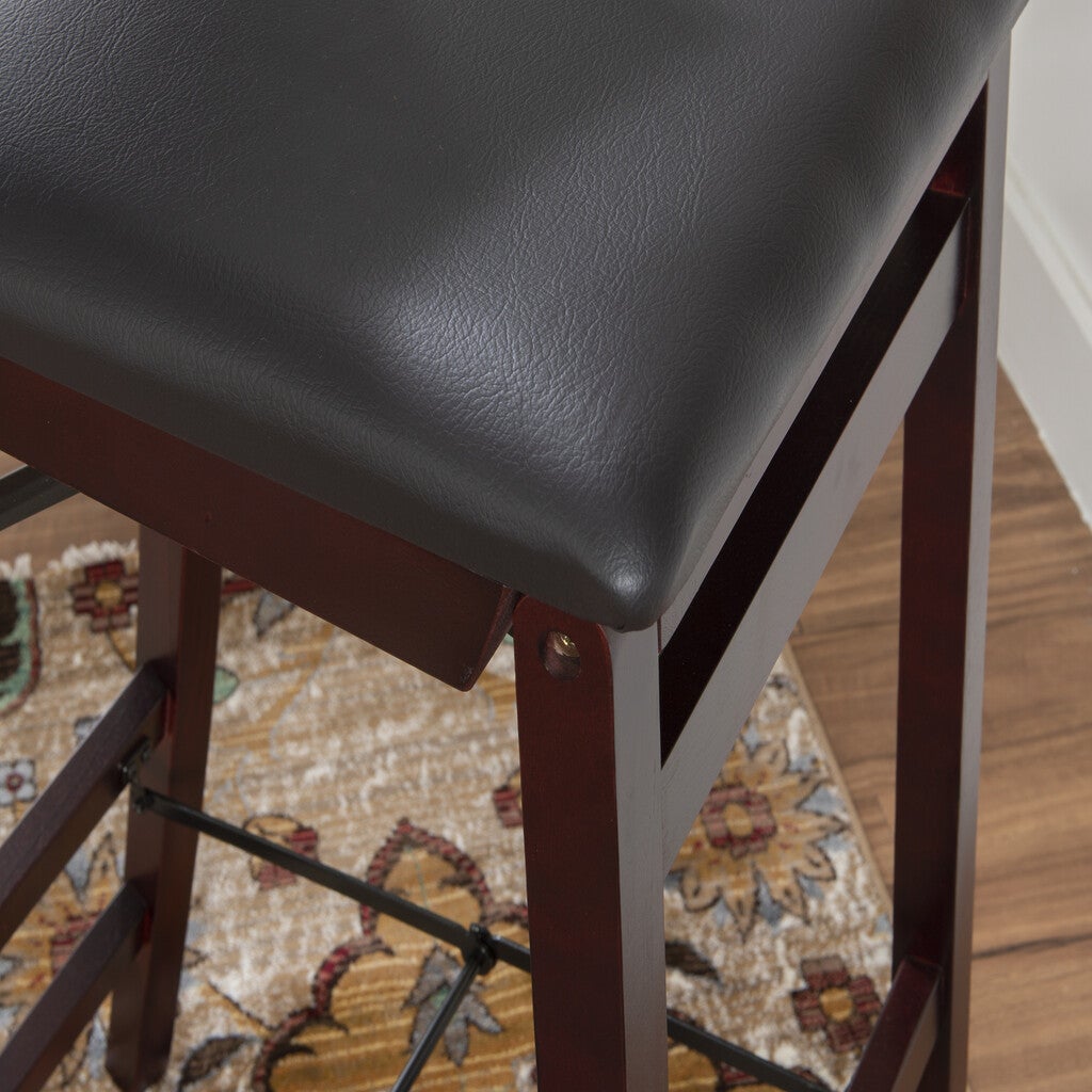 Close-up of a bar stool frame showing bracket and leg joints with black padding.