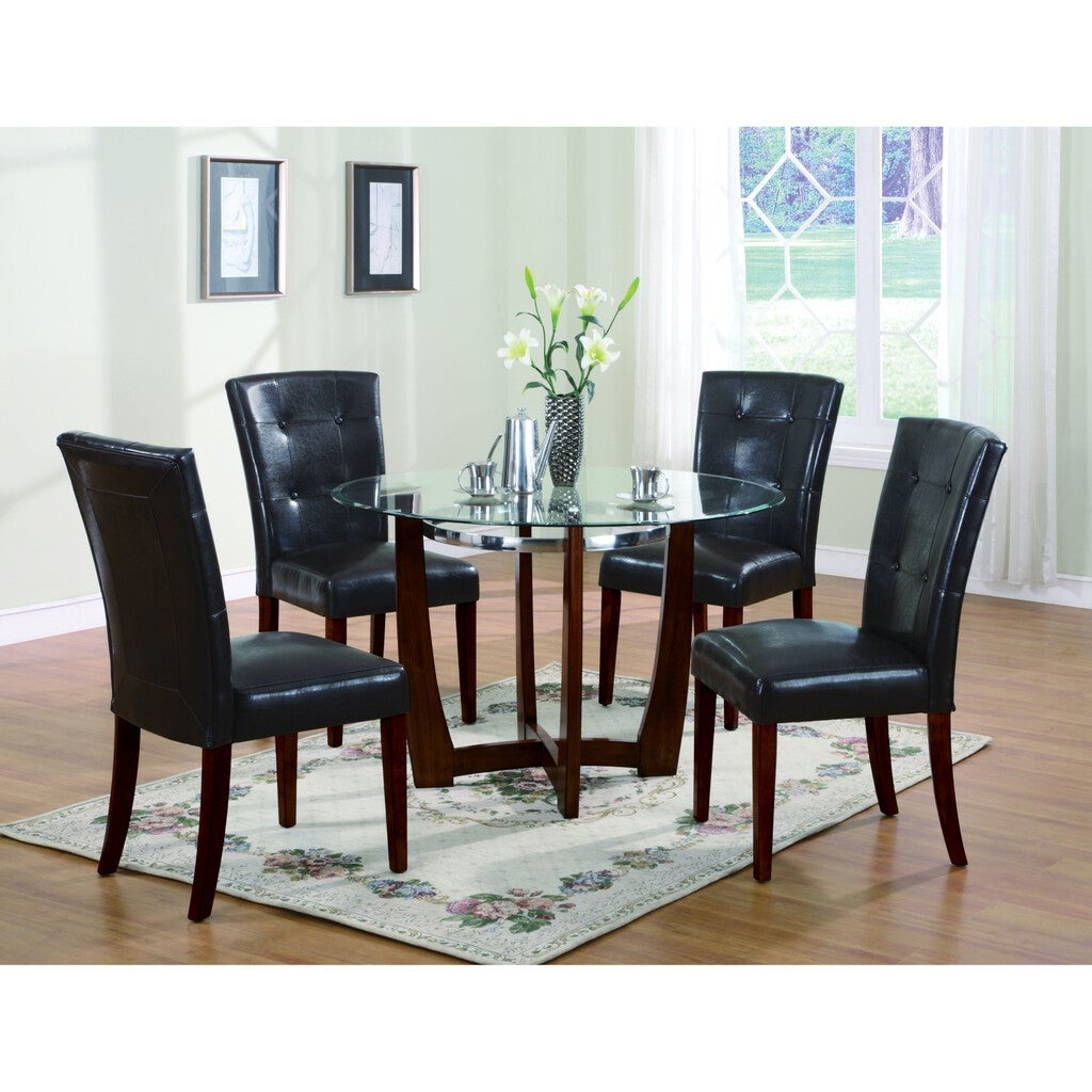 Dining set with a round glass table and four black leather chairs in a bright room