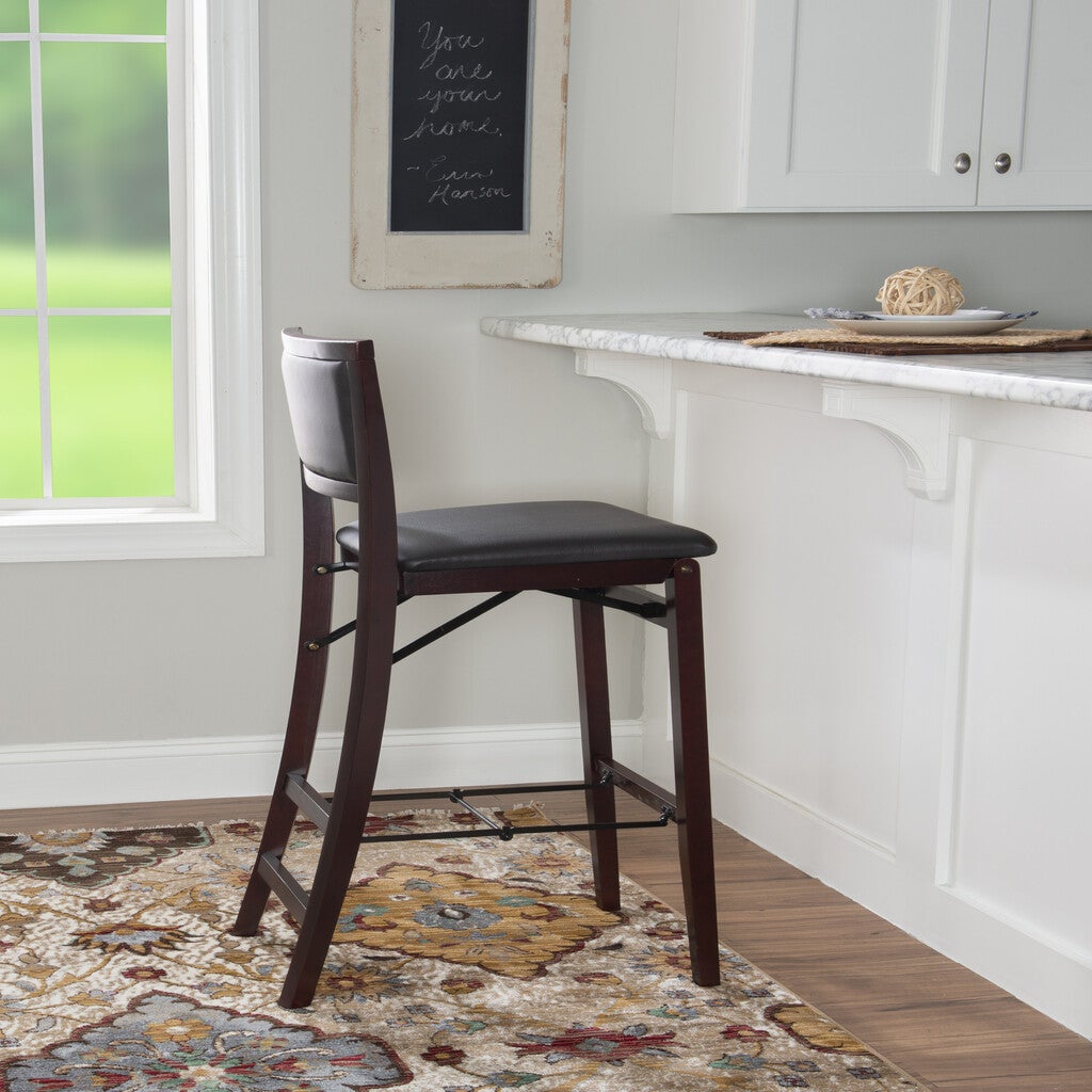 One bar stool with padded seat near a kitchen island, wall chalkboard in background.