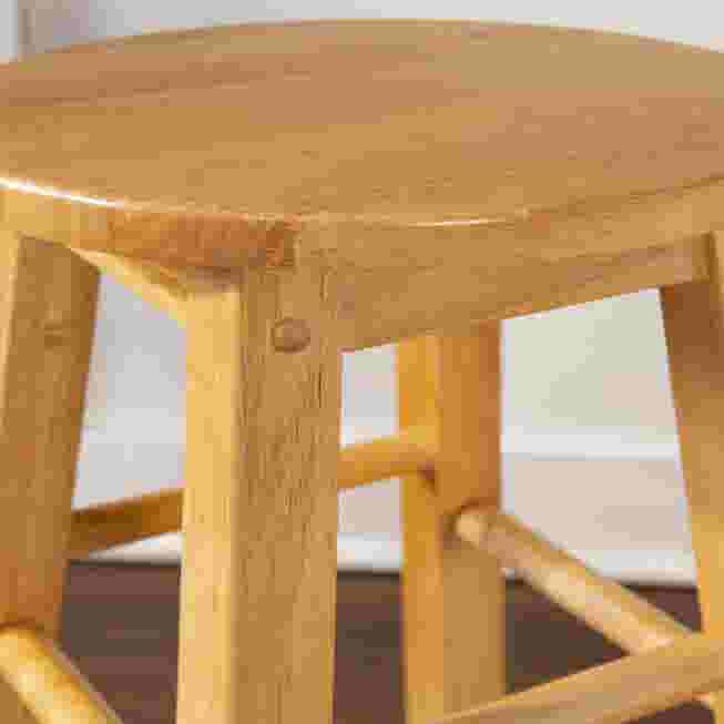Close-up of the wooden stool seat and legs