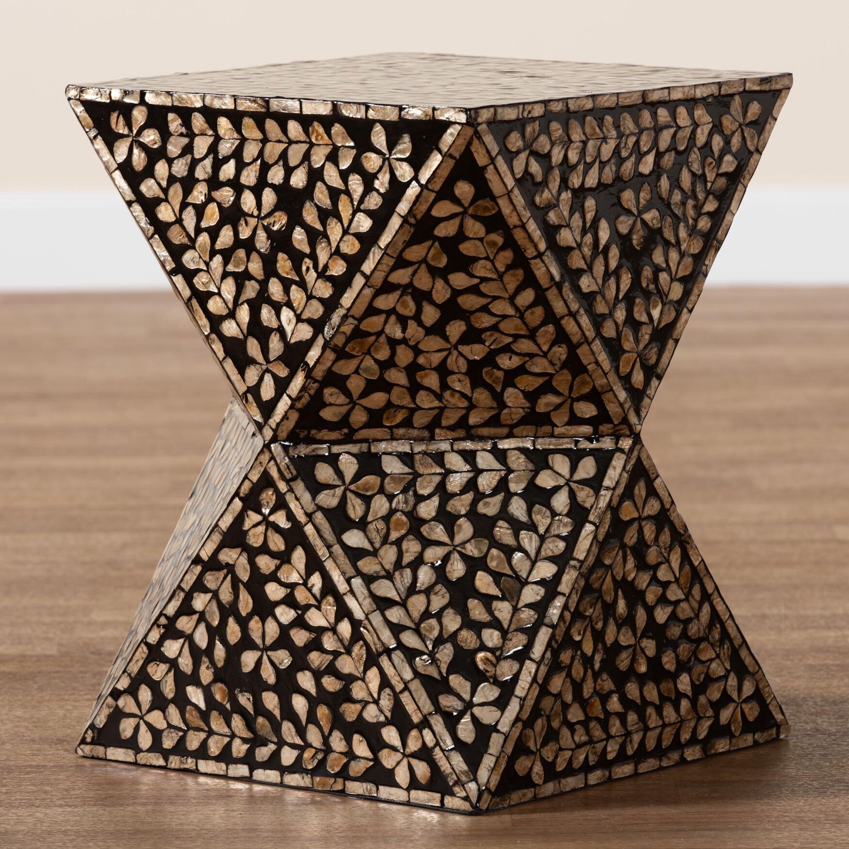 Modern bohemian end table with black and bronze mother of pearl inlay, shown from a side angle.