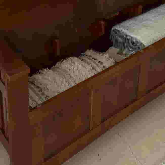 Wooden storage bench with items stored inside