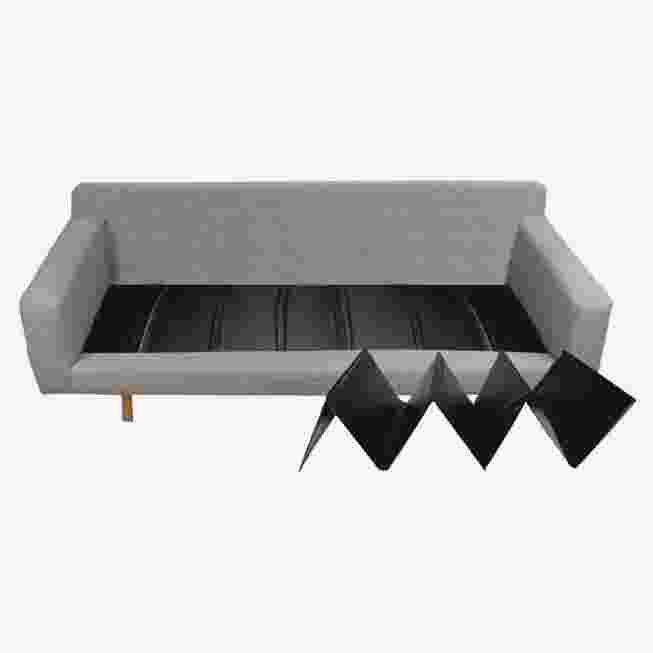 A gray sofa with a black sofa cushion support placed on the seat, demonstrating its use.