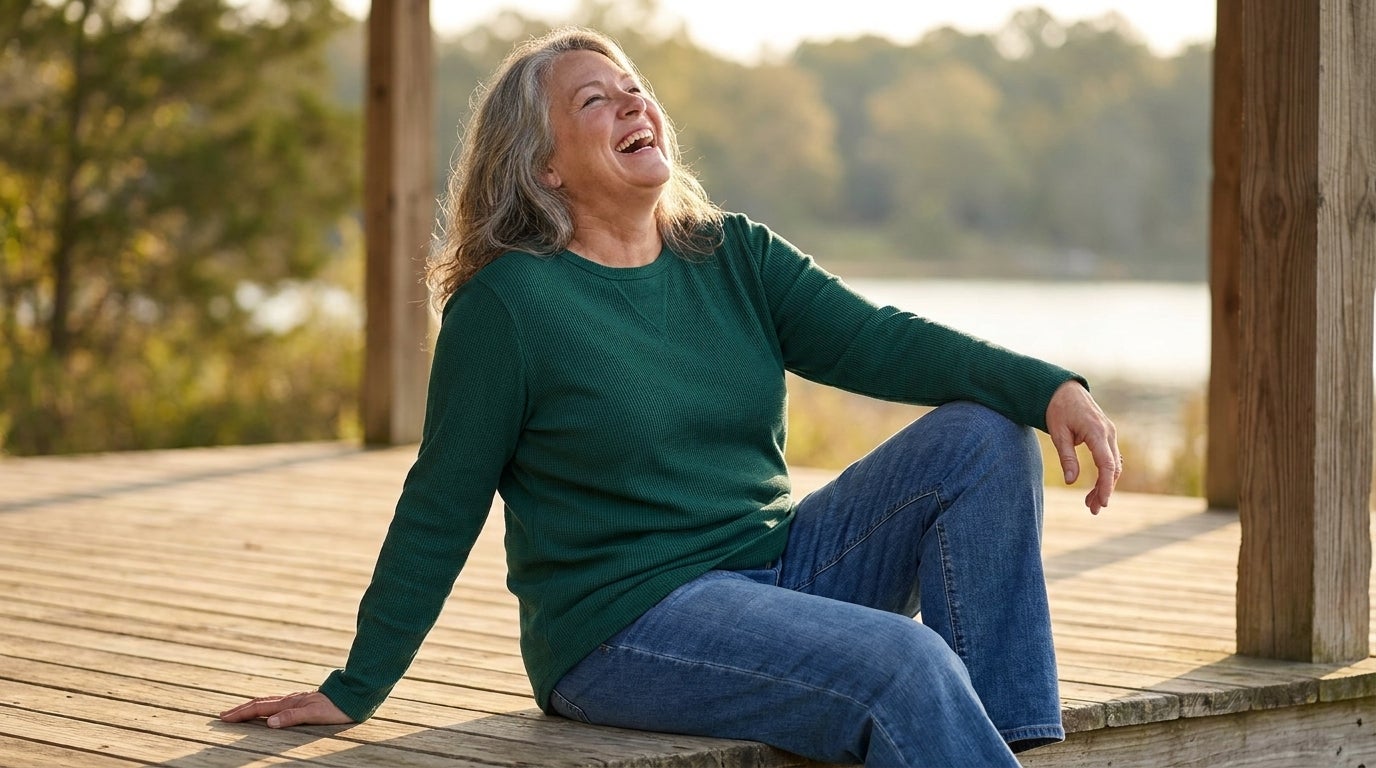 A woman wearing a long-sleeve waffle knit thermal top, smiling in warm afternoon light on a porch.