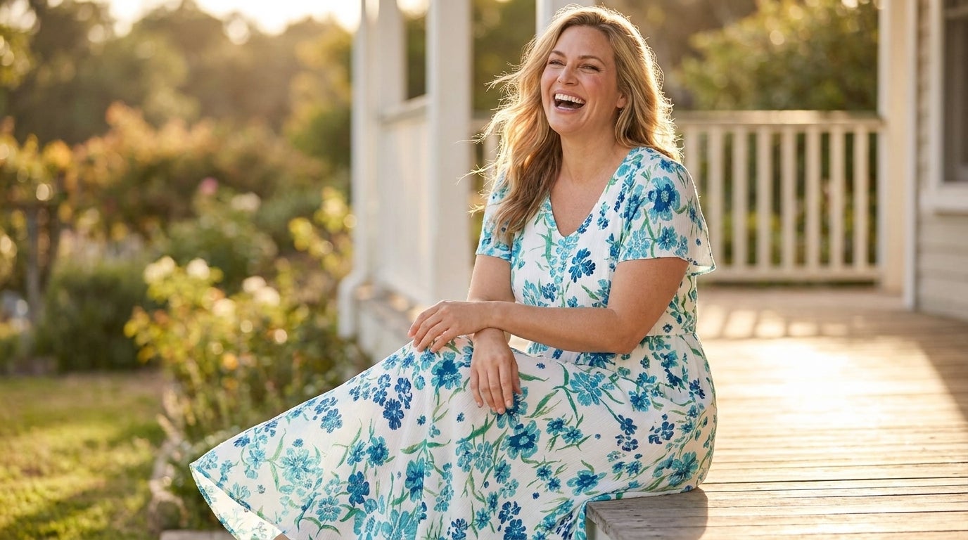 Woman laughing outdoors in a printed crinkle maxi dress with a V-neckline in golden-hour light.