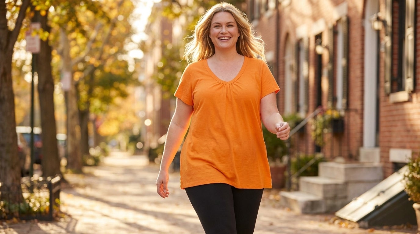 Woman walking outdoors in a short-sleeve V-neck tunic worn over leggings